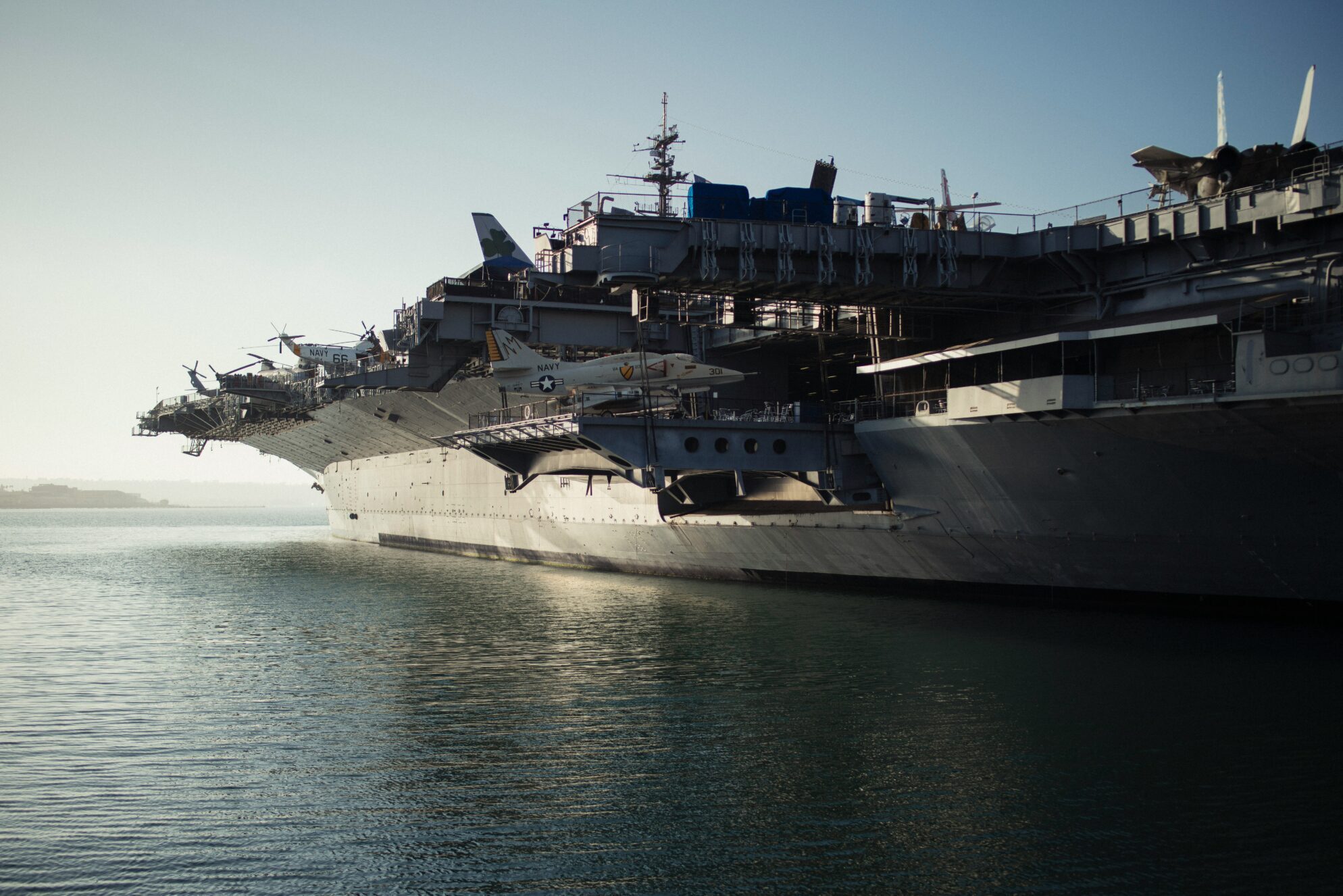 Photo of an aircraft carrier with a US Navy aerial warfighter. Both craft run software that were designed in secure DoD software factories.